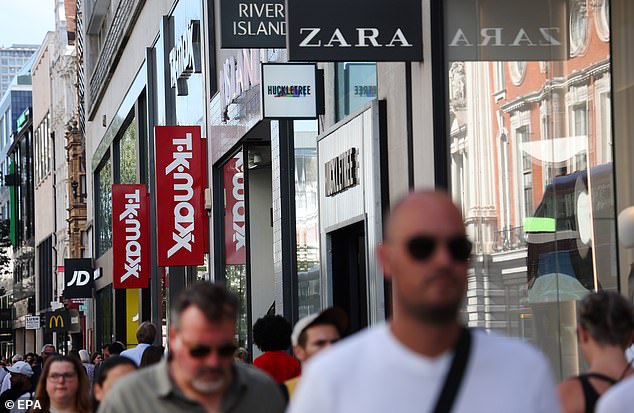 Pedestrians pass brand name retail outlets on Oxford Street in London on September 5, 2023. A coalition of retailer groups have joined to call on police to crack down on shoplifters