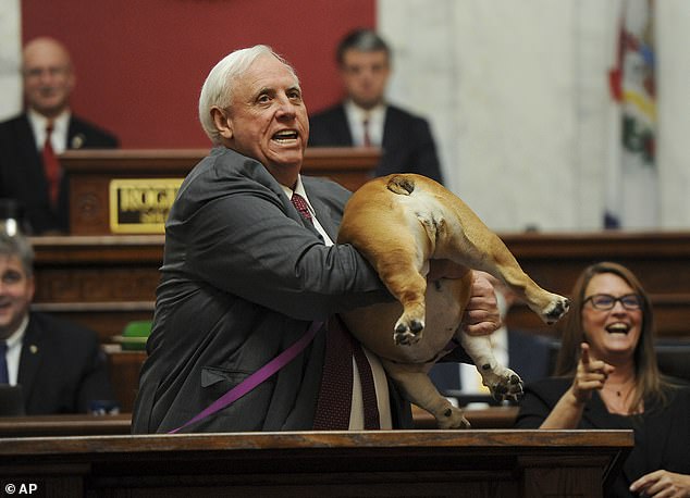 West Virginia Gov. Jim Justice holds up his dog Babydog's rear end as a message to haters during his State of the State speech in the House chambers